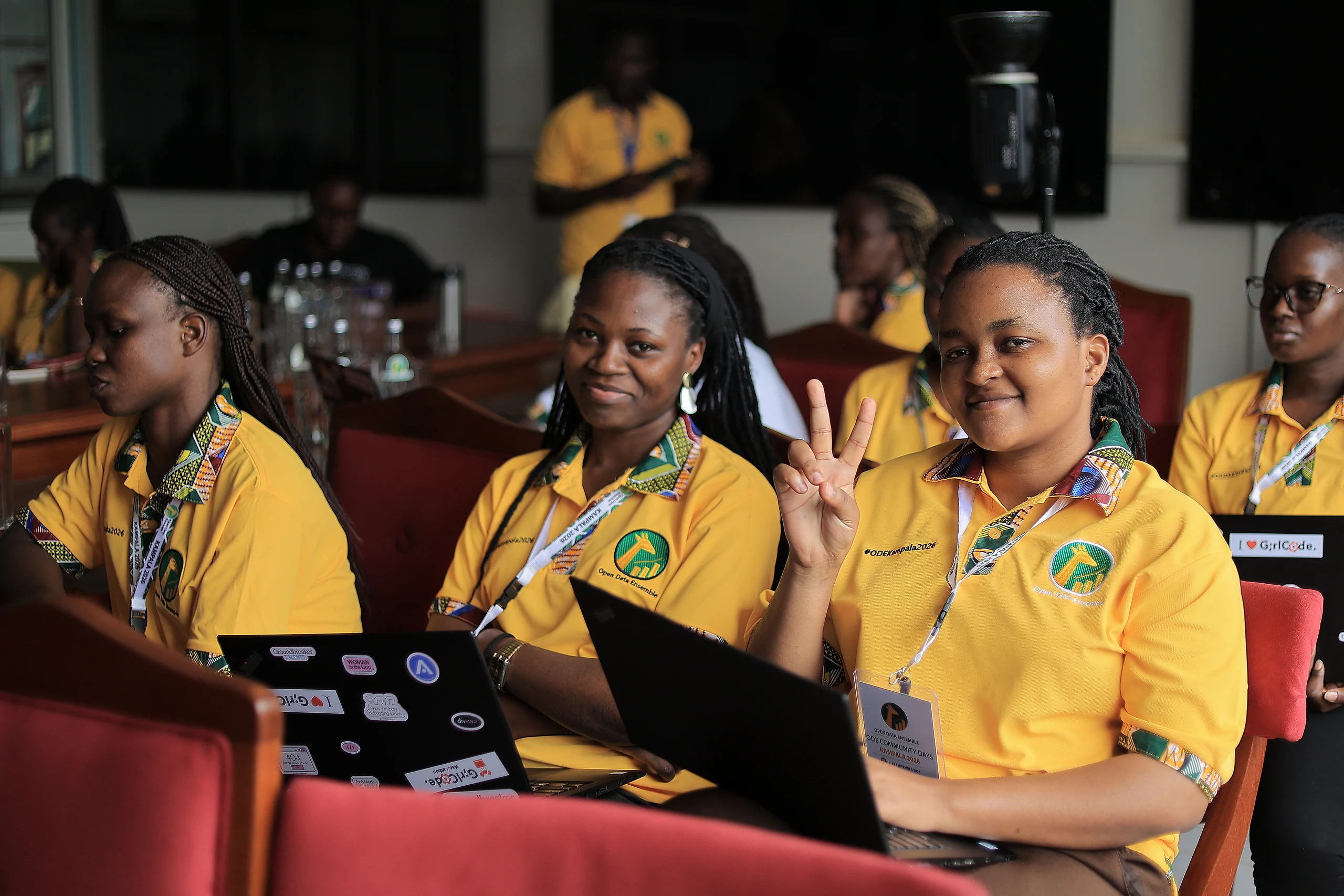 Participants at their laptops, one smiling with a peace sign.