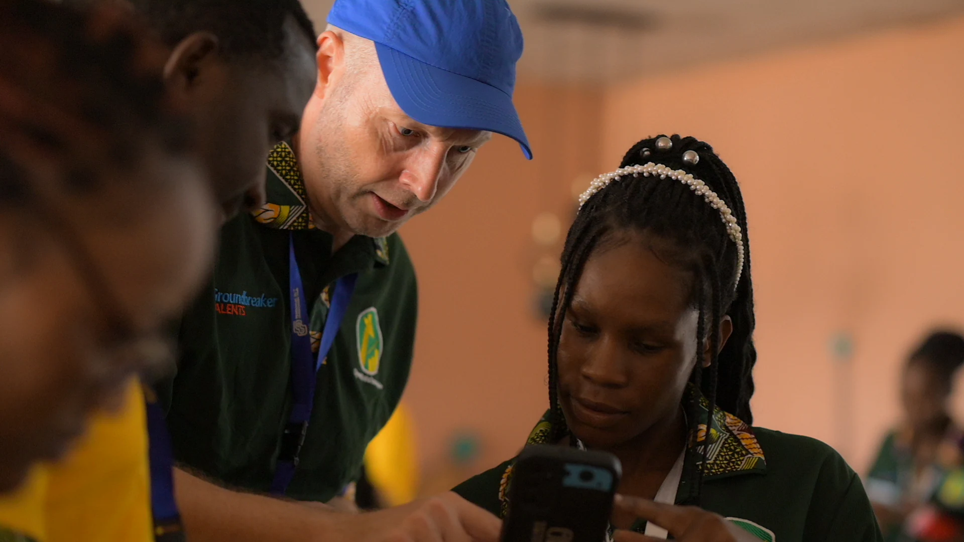 A facilitator helps a participant with an app on her phone.