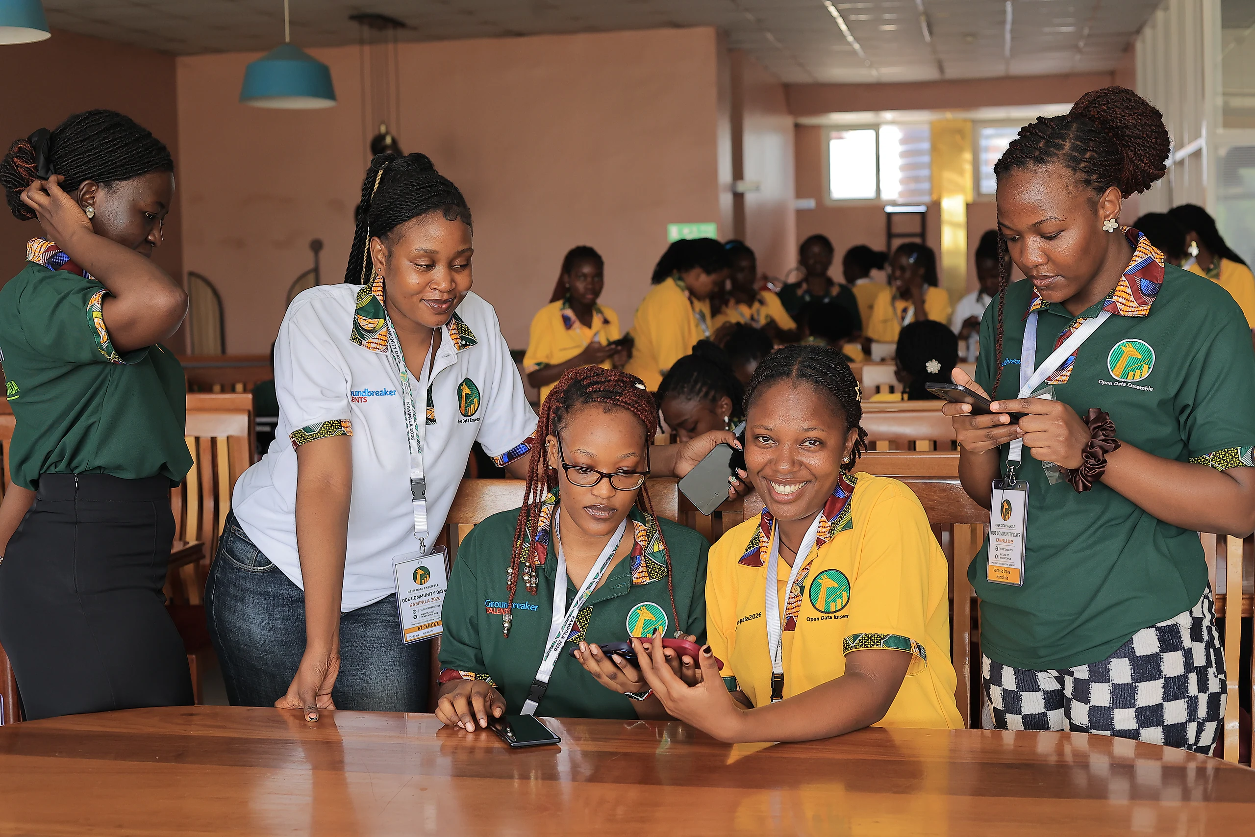 Participants gather around a table, smiling as they compare their phones.
