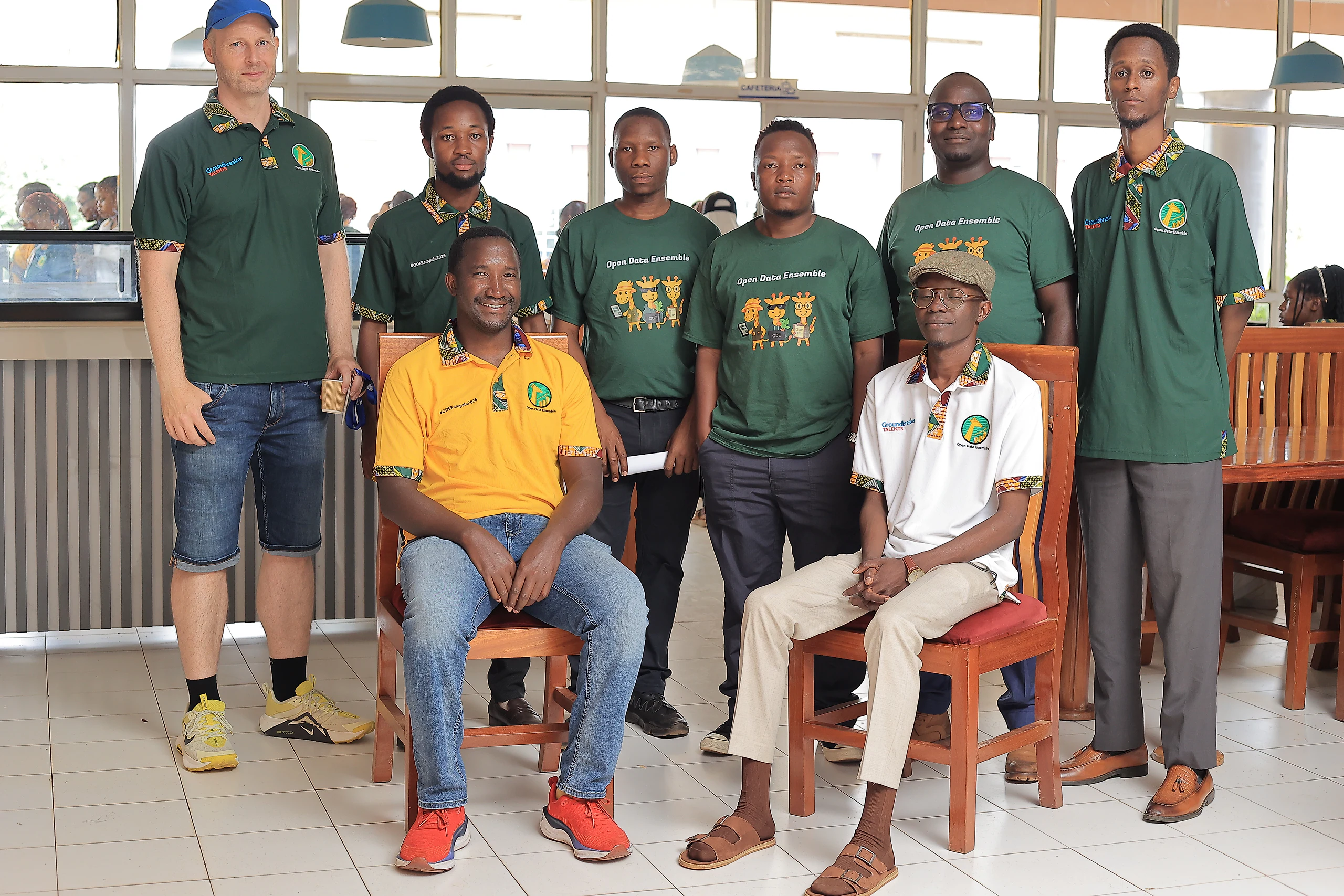 Facilitators and team members pose together indoors.
